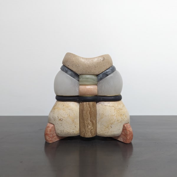 Obscularly shaped sculpture, orange bases holding two yellow pieces layered with black, grey, blue, and brown folding upward