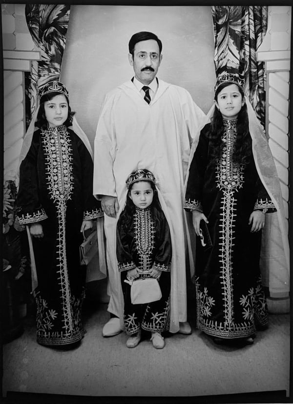 1960s black and white photograph of a father with three children, two older and one younger, all in traditional Algerian attire