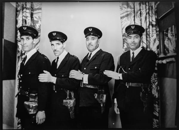 1960s black and white photograph of four policemen in a row standing
