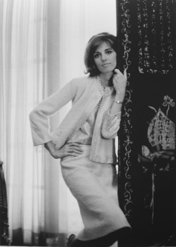 Black and white photograph of a model presenting a Chanel outfit, in Mlle Chanel’s private apartment in the House of Chanel, Paris