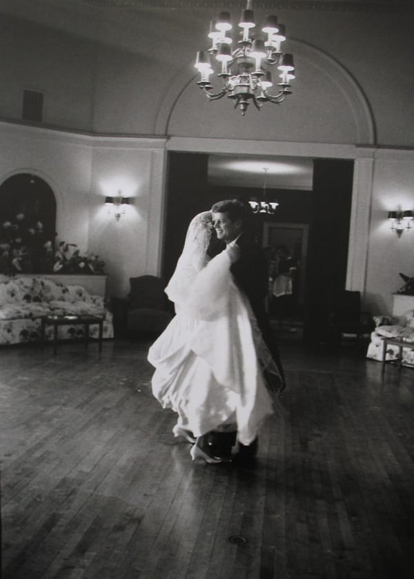 Black and white photograph of John F Kennedy dancing with Joan Bennett Kennedy in a wedding dress in the ballroom of the Bronxville Country Club in New York
