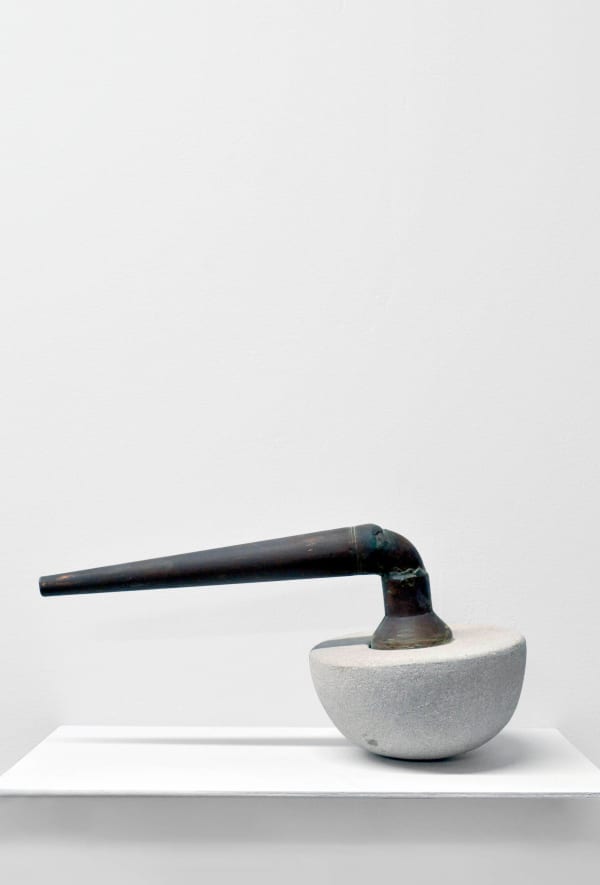 Contemporary minimalist sculpture made of stone and metal that resembles an ambiguous artifact