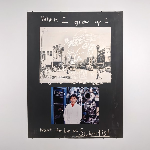 Two photographs on a black board, one is black and white of a street, the other is a young boy, the words “When I grow up, I want to be a Scientist.” written in silver pen on the top and bottom of the page