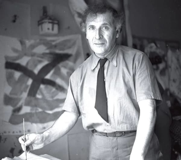 Black and white photograph of artist Marc Chagall working on a painting in a studio setting in Mexico City
