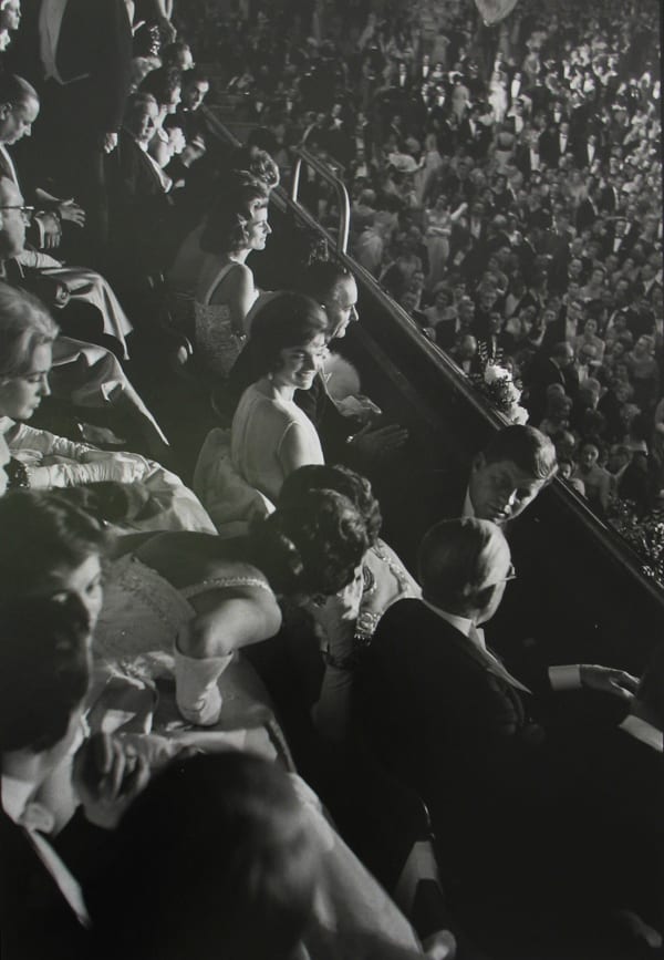 Black and white photograph of John and Jackie Kennedy mingling other attendees seated at the inaugural ball at the Armory
