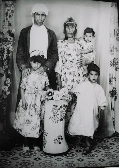 1960s black & white family photograph, father, mother, daughter, son, baby held by mother, in tribal garb, in a photo studio