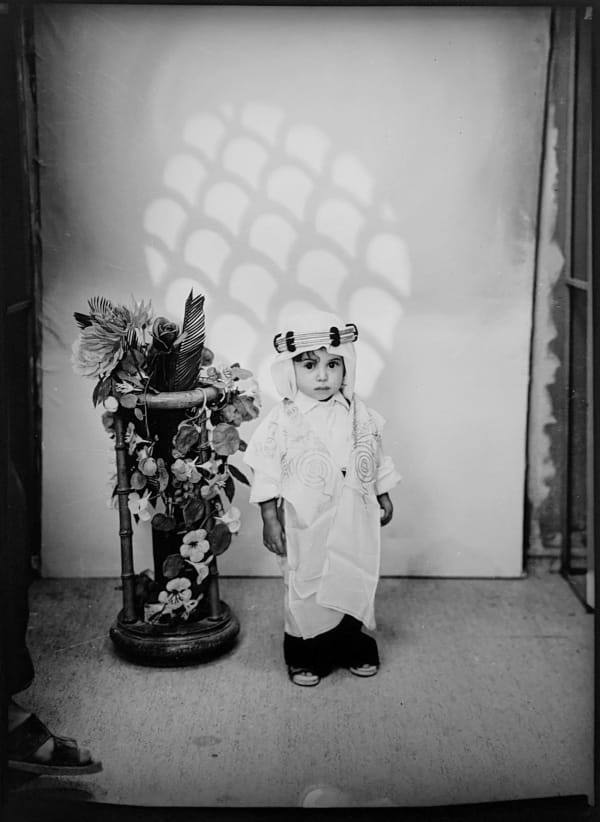 1960s black & white photograph of a young child wearing ethnic Middle-Eastern garb in a photography studio
