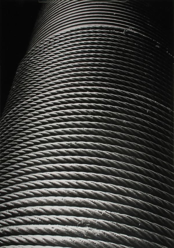 Black and white close-up photograph of a rope coiled in a cylinder shape