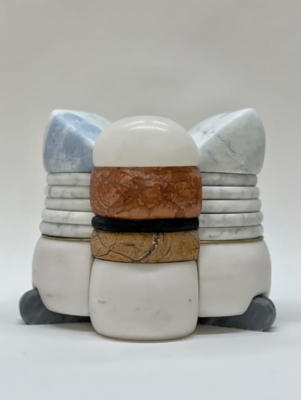 Multilayered, complex sculpture with three side-by-side parts, layering in white and an orange, yellow, and black center
