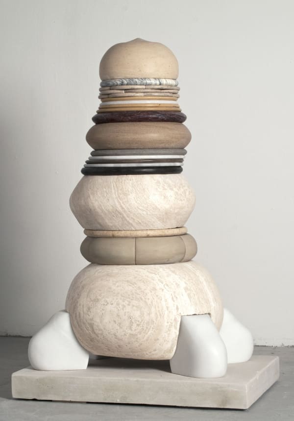 A multi-colored and layered sculpture in neaurals with different mediums and sizes on each layer, the shapes are rounded.