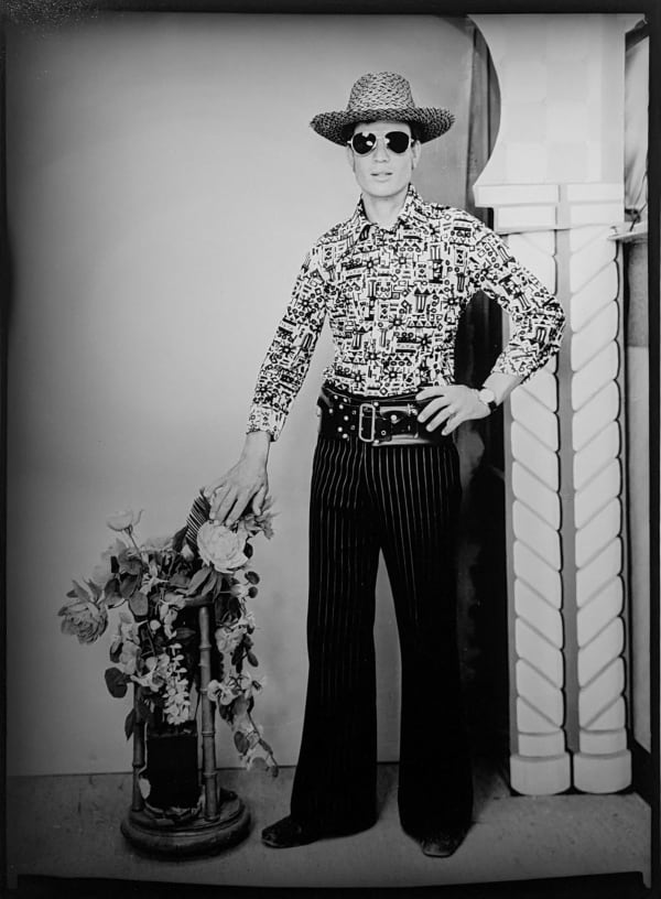 1960s black and white photograph of a man standing wearing western attire