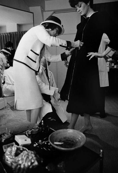 Black and white photograph of Coco Chanel with model Constance Fenton, House of Chanel, Paris