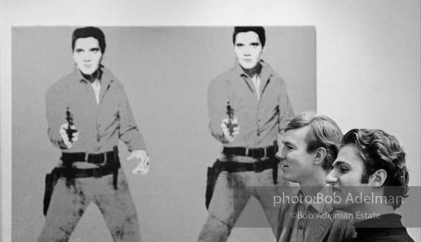 Bob Adelman, Andy Warhol and Gerard Malanga with "Elvis I" on exhibit at Leo Castelli Gallery, NYC, 1965