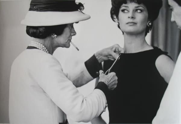 Black and white photograph of Designer Coco Chanel working on model Constance Fenton in the House of Chanel