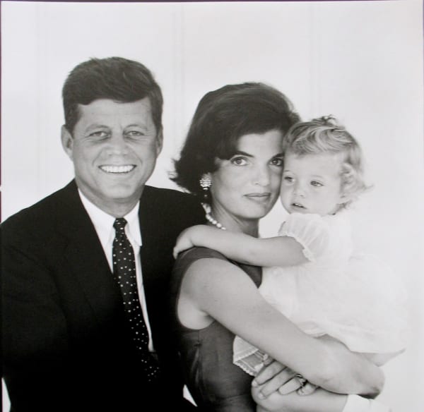 Black and white photograph of Jackie, John, and Caroline Kennedy posing against a white background for a Christmas card