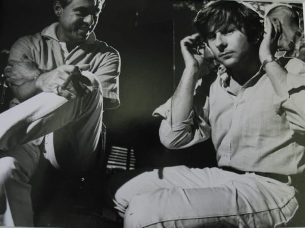 Black and white photograph of Roman Polanski gesturing audio instructions to the crew on the set of “Rosemary’s Baby”