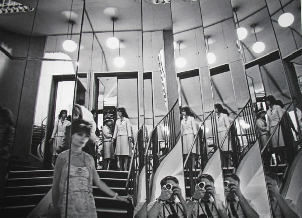 Black and white photograph of preparations for a fashion show refracted in the many mirrors of the staircase at the House of Chanel in Paris