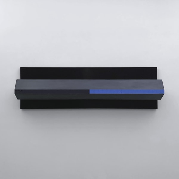 Aluminum and wood tridimensional painting painted black. A large flat black rectangle mounted on the wall with a rectangular black prism with a blue stripe on the front face attached.