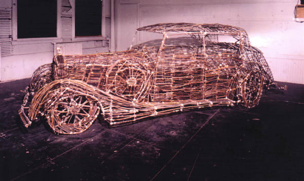 Sculpture of a car made of twigs, tree branches, bamboo, twine, adhesive to bind knots