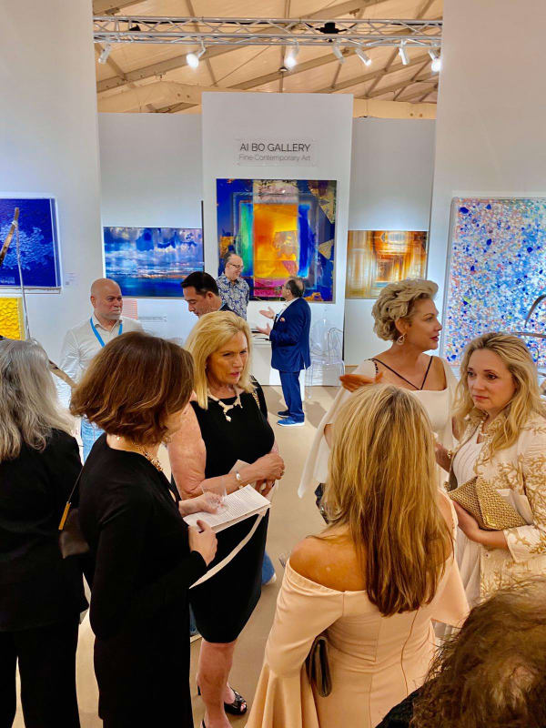 Image of several guests in the Ai Bo Gallery booth at the Palm Beach show