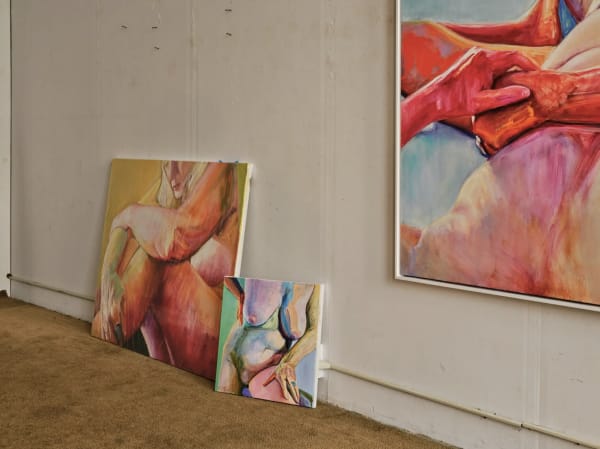 On the floor, leaning against a larger canvas titled “Center Elbow” (2020), is a highly colored and as yet untitled fleshy nude. On the wall is “Spaced Out” (2020), a painting of a reclining figure with red-tinged hands and limbs. Photo: Emiliano Granado
