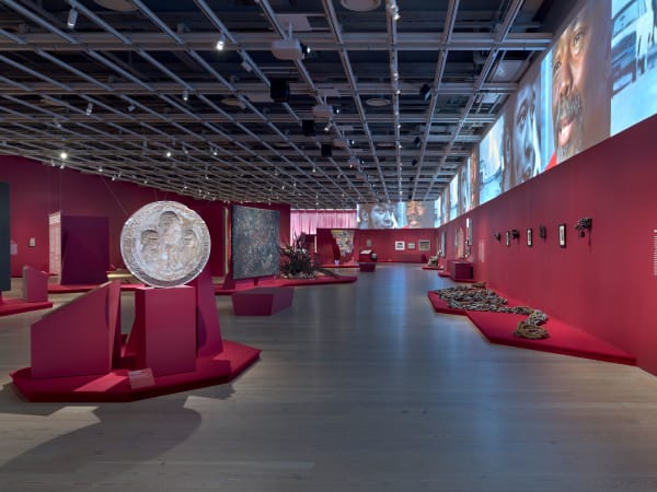 Installation view of Edges of Ailey (Whitney Museum of American Art, New York, September 25, 2024-February 9, 2025). From left to right: Purvis Young, Ocean, 1975; Meta Vaux Warrick Fuller, Mold for Crusaders for Freedom, 1962; Sam Gilliam, Untitled (Black), 1978; David Hammons, Untitled, 1992; Al Loving, Untitled, c. 1975; Hale Aspacio Woodruff, By Parties Unknown, 1935, printed 1996; Hale Aspacio Woodruff, Giddap, 1935, printed 1996; Purvis Young, I Love Your America, late 1970s; Martin Puryear, The Rest, 2009-10; Samella Lewis, Migrants, 1968; Purvis Young, Black People Migrating West, late 1970s; William H. Johnson, Moon Over Harlem, 1943-44; Lonnie Holley, Sharing the Struggle, 2018; Theaster Gates, Minority Majority, 2012; Sam Doyle, Frank Capers, 2023; Sam Doyle, LeBe, 1970s; Wadsworth Jarrell, Together We Will Win, 1973; Faith Ringgold, United States of Attica, 1971; Wadsworth Jarrell, Revolutionary (Angela Davis), 1972; James Van Der Zee, Marcus Garvey Rally, 1924; Jeff Donaldson, Soweto/So We Too, 1979; Maren Hassinger, River, 1972/2012; Maren Hassinger, River, 1972/2012; Melvin Edwards, Utonga (Lynch Fragment), 1988; Aaron Douglas, Bravado, 1926; Melvin Edwards, Chitungwiza from the Lynch Fragment series, 1989; Aaron Douglas, Flight, 1926; Melvin Edwards, Katura from the Lynch Fragment series, 1986; Aaron Douglas, Surrender, 1970; Melvin Edwards, Cup of? From the Lynch Fragment series, 1988. Photograph by Ron Amstutz