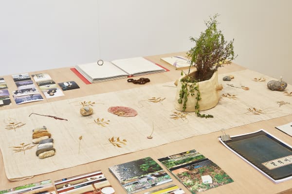 Untitled (Table), 2018 Books & photos (collection of Chingu sai), Buddy Issue 8 (collection of Chae-yoon Han), scrap metal, pressed flowers & pebbles from Prospect Cottage, Joon-soo Oh’s scrapbook (collection of Geun-jun Lim), gold thread embroidery on sambe, ring (collection of Hyung-jun Choi), photos from Prospect Cottage and various places in Seoul, ceramic (California clay, soils from Derek Jarman’s Garden, Nam San, Tapgol Park), plant collecting & arrangement by Yuhur Collection of National Museum of Modern and Contemporary Art, Korea