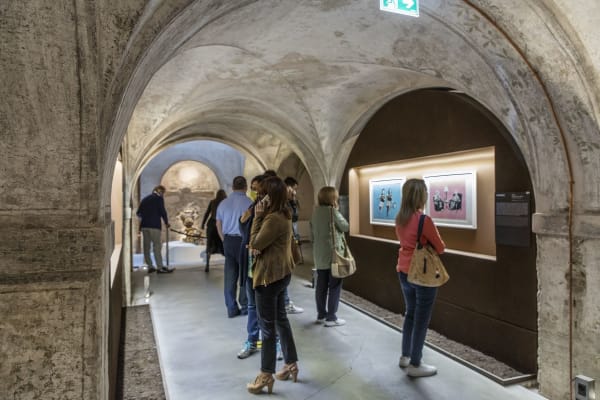 Banksy artwork hanging on wall, people looking at art
