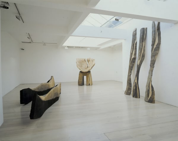David Nash, recent Sculpture, Annely Juda Fine Art, London, 1996. description; an installation shot of a white gallery space with large carved wooden sculptures