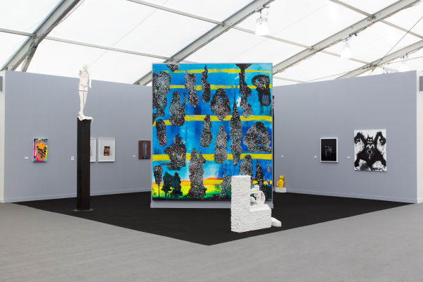 Installation view at the fair. Gray walls and works scattered among them. Many large paintings are shown.