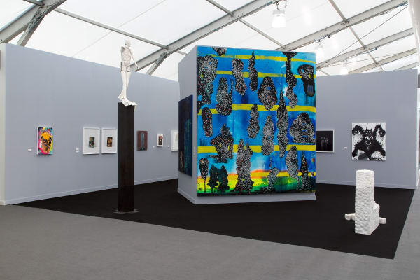 Installation view at the fair. Gray walls and works scattered among them. Many large paintings are shown.