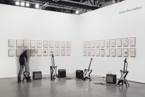 David Shrigley solo booth at the Independent Art Fair, with drums, a gong, and drawings.
