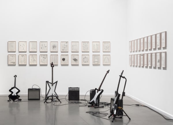 David Shrigley solo booth at the Independent Art Fair, with drums, a gong, and drawings.