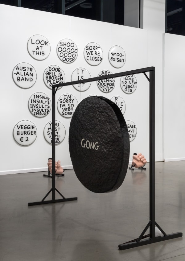 David Shrigley solo booth at the Independent Art Fair, with drums, a gong, and drawings.