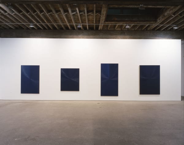 Installation view of Mark Grotjahn's second show at Anton Kern, featuring ten blue paintings descending (or ascending) in tones, shades, dynamics of blues. Four blues of varying sizes.