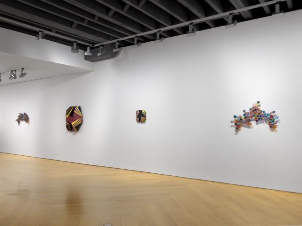 Installation view of Jim Lambie's works on the 3rd floor of the gallery featuring sunglass sculptures and metal boxes. This image presents three works by Lambie.