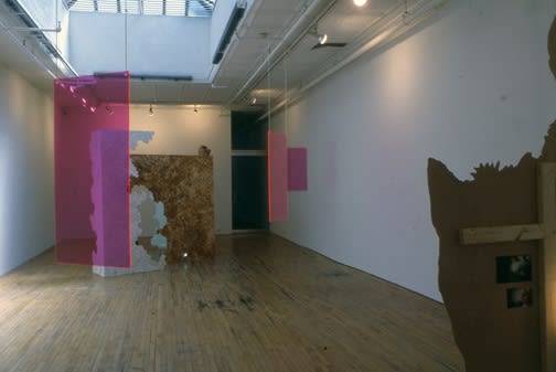 Installation view of Lothar Hempel's show titled "America Disappears Only the Smile Remains," featuring plexiglass works, cardboard cutouts, and other photocollages. Most of the works featured.