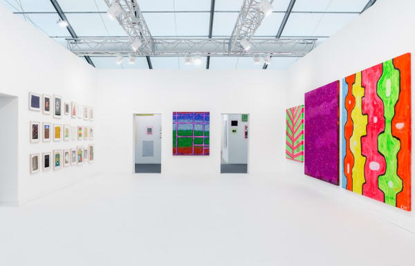 Installation view of Chris Martin's solo exhibition at Frieze London 2015. Straight-on view of entrance into booth.