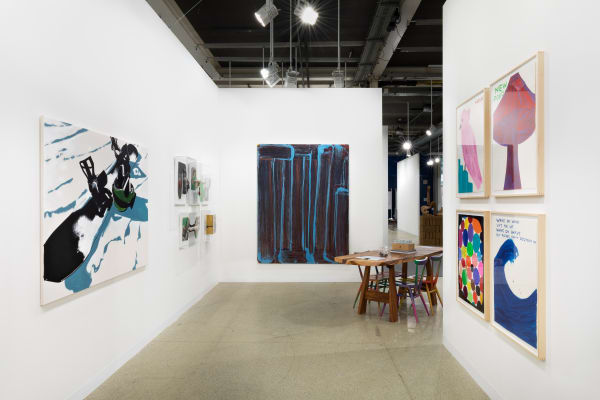 Installation view of Art Basel featuring a blue painting by Richard Janitz on back walll.