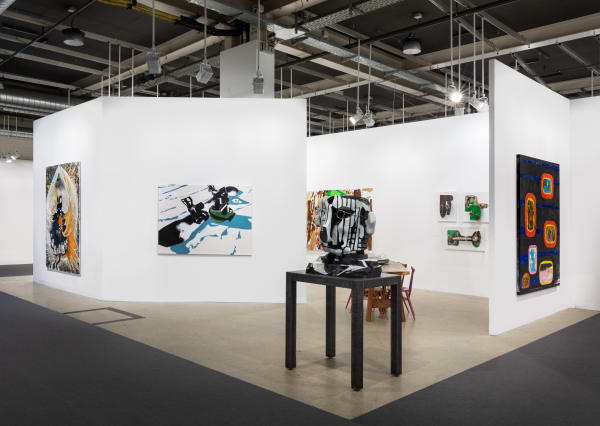 Installation view of Art Basel featuring the majority of works in the both, including sculptures, paintings, and more.