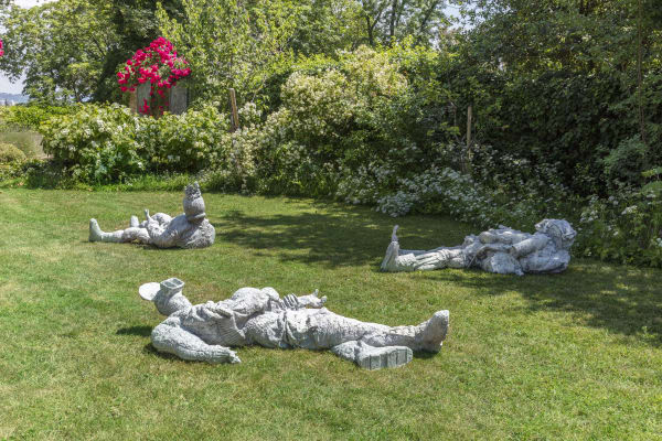 Installation view of Art Basel Parcours 2023 with view of grass, trees, and 3 artworks by Paweł Althamer