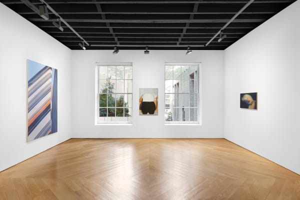 Installation view of the 2023 exhibition “Eberhard Havekost: Paintings 1998-2016” with view of wood floors, walls, windows, artworks and ceiling.