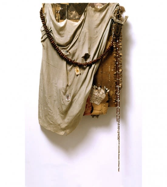 An assemblage sculpture of fabric, lace, and beads