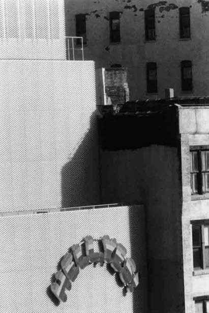 A black and white photograph of buildings with a sign reading "hell yes"