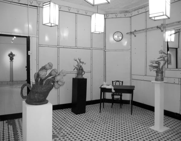 Black and white photograph of three sculptures on pedestals