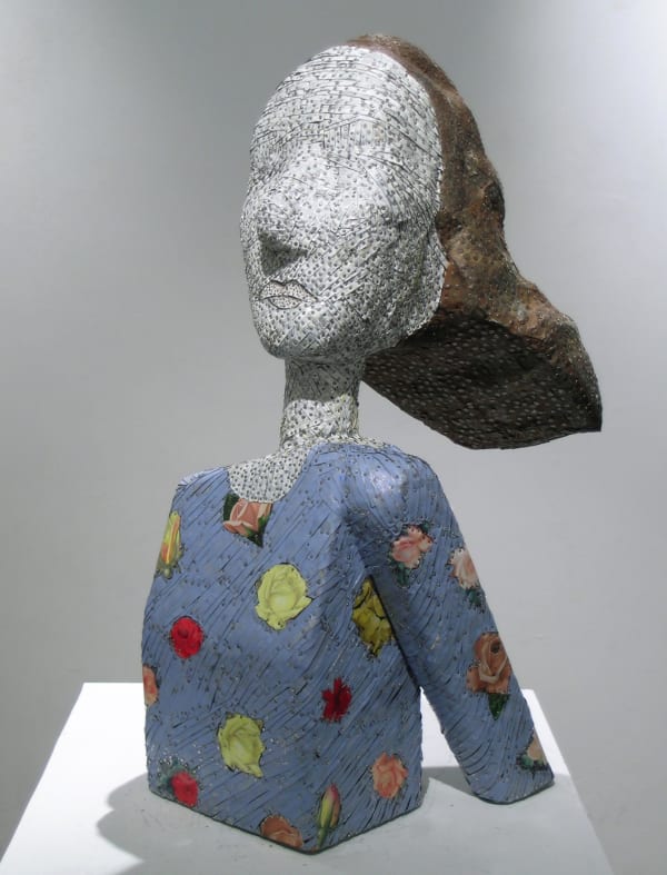 An abstracted bust of a woman made from many strips of colored tin with a breeze blowing her hair back