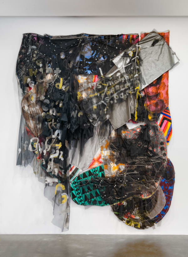 A billowing banner resembling many layers of dark bunting made from scraps of fabric