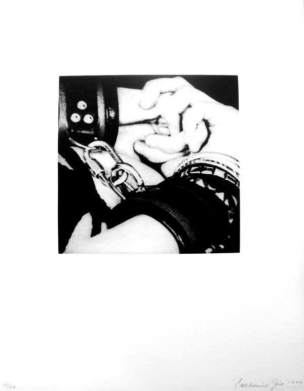 Image of two clenched hands in leather BDSM wrist-cuffs