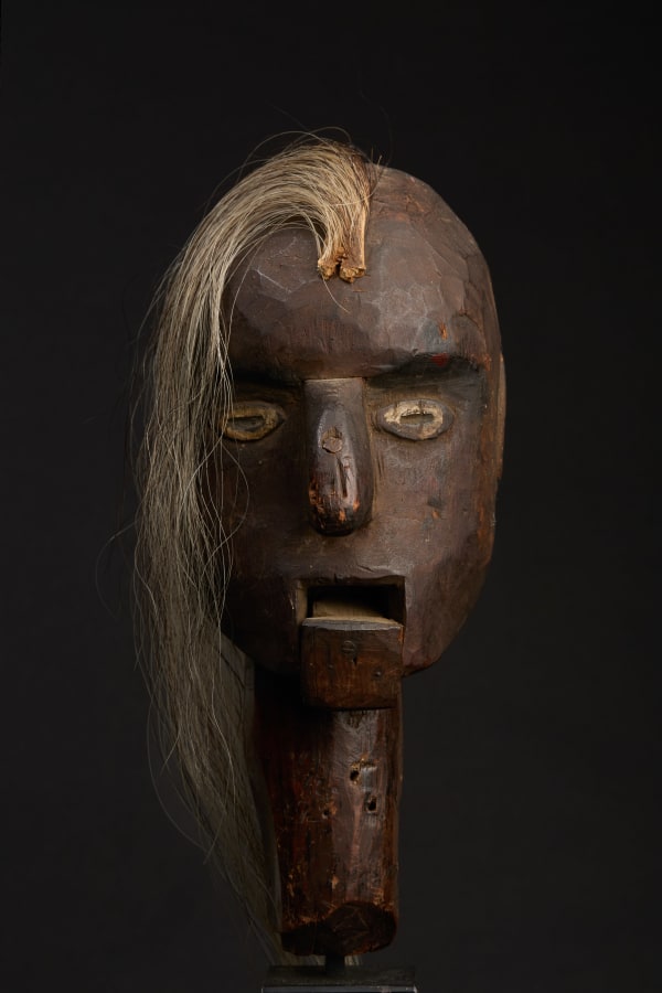 Ventriloquist Head, American, mid-to late 19th century Carved and painted wood with horse hair 10 x 4 x 6 in (25.4 x 10.2 x 15.2 cm) (ArU 475) $ 5,000 ••• Radiating an otherworldly energy, this raw creation of the American folk imagination mesmerizes with its eerie presence. Its patinated wood and hauntingly rough-hewn features evoke a primal, almost shamanic energy. The mechanical mouth feels both inviting and unsettling, as if it might unleash a voice beyond time. The shock of horsehair, cascading in an unruly mane suggests life caught between the natural and the supernatural. This isn't just a functional object; it's an existential dialogue—crafted by anonymous hands yet charged with personality, humor, and perhaps a touch of menace. It's as if the soul of the carver whispers secrets through it, forever performing.