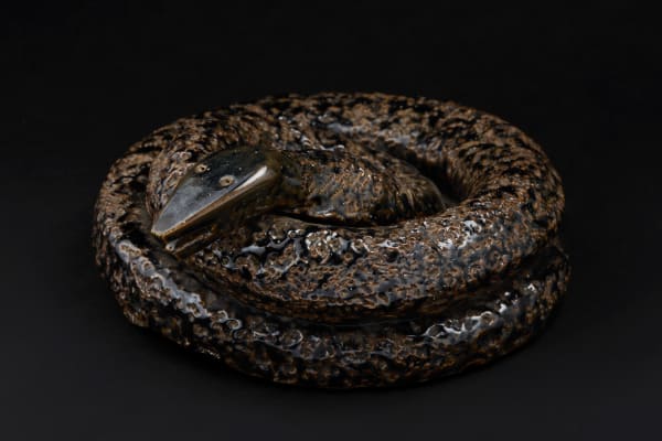 Coiled Snake, ca. 1900 Fired clay with glaze 8 x 7 1/2 x 4 in (20.3 x 19.1 x 10.2 cm) (ArU 484) $ 5,000 ••• This snake exudes an untamed energy captured in fired clay. Its textured surface, alive with glossy glaze, feels like molten earth solidified mid-motion. The head, sharp and alert, pierces through the loop of its body with an almost sinister calm, capturing the eternal tension between beauty and menace. You can almost feel the pulse of its latent power, as though it might slither off its pedestal at any moment.
